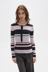 Remera de manga larga confeccionada en tejido de punto acanalado con diseño de rayas horizontales en tonos azul marino, rosado y celeste. Presenta un cuello redondo a la base con una pequeña abertura frontal cerrada por una hilera de botones.