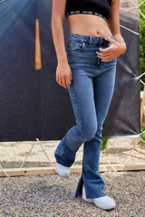 Pantalón de jean azul de tiro alto, corte semi oxford con botamanga ancha y abierta, y ruedo al corte.