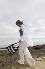 Cartera tejida a crochet con hilo 100% de algodón. Diseño a rayas horizontales en tonos de rojo y rosa, con volados en el borde y en el asa.