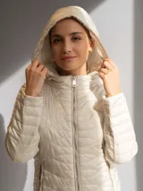 Campera acolchada color fucsia, con cierre frontal y capucha. Presenta un diseño capitoneado con costuras onduladas.