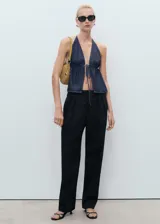 Pantalón de vestir negro de corte recto y tiro bajo, con pinzas frontales, bolsillos laterales y cierre oculto con botón, gancho y cremallera.