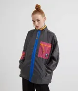 Campera larga color gris con cierre frontal azul, cuello alto y bolsillos laterales. Tiene un parche con diseño geométrico en el pecho. Marca Blue Steel.