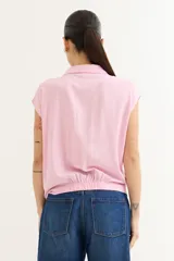 Camisa rosa de viscosa con cuello camisero y mangas cortas. Se anuda en la parte delantera.