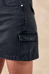 Minifalda de denim color gris oscuro, con tiro alto, bolsillos laterales tipo cargo y corte recto.