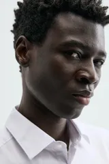 Camisa de hombre color beige claro, de corte slim fit, con cuello italiano, manga larga y cierre frontal de botonadura.