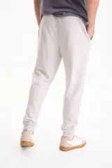 Pantalón de jogging negro sin friza, con puños elastizados en los tobillos y cordón ajustable en la cintura.