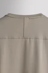 Camiseta deportiva de manga larga Zara Athleticz, de corte regular fit y color marrón topo. Confeccionada en tejido técnico elástico de secado rápido, cuenta con cuello redondo y detalle de logo estampado en el bajo.