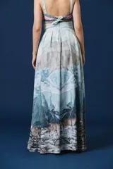 Falda larga de tiro alto con diseño estampado de paisaje montañoso y ciervos. Presenta una silueta amplia con tablas en la cintura y caída fluida.