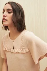 Blusa negra con textura, canesú con encaje, volados, corte fluido y mangas cortas amplias.