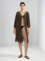 Cárdigan marrón de punto abierto con flecos en el ruedo y lazo de ajuste en el escote.