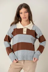 Buzo de tejido de punto con diseño de rayas horizontales anchas en color gris y marrón. Presenta cuello polo en tono crema con cierre frontal de dos botones y mangas largas con puños acanalados.