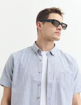 Camisa de manga corta con cuello abotonado y estampado a rayas verticales color beige y blanco.