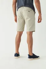 Bermuda de gabardina azul marino, corte chino, con bolsillos laterales y traseros.