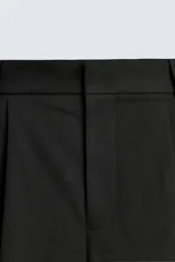 Bermuda negra de corte ancho (wide fit) con pliegues frontales, bolsillos laterales y bolsillos traseros de vivo.