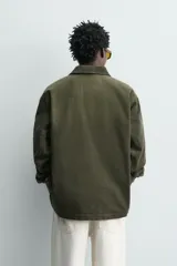 Cazadora relaxed fit de algodón color verde militar, con efecto lavado, cuello solapa de pana a tono y manga larga. Cuenta con bolsillos de plastrón delanteros y cierre frontal de botonadura.