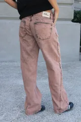 Jean de corte recto y tiro medio, color rosado con efecto acid wash y costuras diagonales en negro.