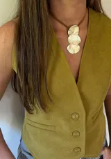 Collar con colgante de tres piezas irregulares de alpaca plateada, engarzadas en un cordón doble de cuero marrón.