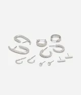 Set de aros plateados con diferentes diseños: argollas lisas, argollas trenzadas, aros tipo botón con strass, aros tipo barra y aros con forma de U.
