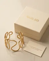 Brazalete rígido de acero con baño de oro, con diseño de ondas entrelazadas y acabado texturizado.