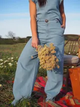 Pantalón de jean color celeste claro, de corte ancho y relajado, con cintura alta, trabillas para cinto y un botón frontal visible.