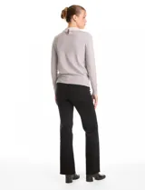Buzo de punto fino color gris, con cuello camisero de gasa integrado decorado con apliques de perlas y brillos. Presenta mangas largas y puños acanalados.