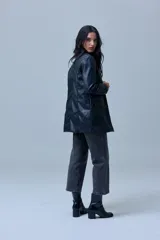 Blazer de eco cuero negro con cuello de solapa, cierre frontal con botones y bolsillos aplicados en la parte delantera. Cuenta con forro interno a tono.