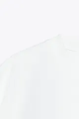 Camiseta gris con efecto lavado, cuello redondo con ribete y mangas cortas tipo capa.