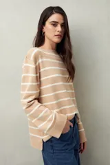 Sweater de punto color crema con rayas horizontales azul marino, cuello redondo y corte recto.