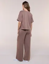 Conjunto de buzo de manga corta con hombros caídos y escote redondo, acompañado de un pantalón tipo wide leg de tiro alto con cintura elástica y cordón de ajuste, en color verde.