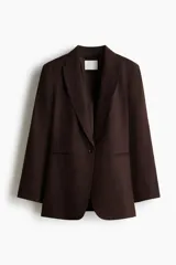 Blazer de botonadura sencilla en mezcla de lino color marrón. Modelo entallado con hombreras, solapas de pico, bolsillos delanteros ribeteados, un botón de cierre y forro interior.
