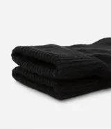 Par de guantes cortos de punto color negro, sin dedos.