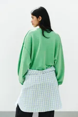 Sudadera de algodón color verde brillante con efecto lavado, cuello redondo con detalle de costura triangular, manga larga y acabados en rib.