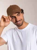 Gorra de pana color camel con visera curva y logo bordado en el lateral.