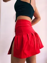 Minifalda tableada de bengalina color rojo, negro y blanco, con cierre metálico lateral.