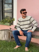 Sweater de punto con cuello redondo, diseño de rayas horizontales en tonos oscuros sobre base clara, de manga larga y calce cómodo.