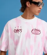 Remera oversized de algodón con teñido tie-dye en blanco y rosa. Presenta un cuello redondo y un estampado frontal con la palabra "Chaos" y un diseño de llamas en color rosado.
