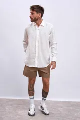 Camisa de lino color crudo, de corte recto, con cuello clásico y mangas largas.