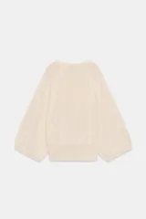 Jersey de punto color terracota, con cuello redondo y mangas amplias tipo murciélago.