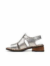 Sandalias de cuero natural metalizado color plateado, con tiras anchas, taco bajo de madera y tira con velcro para ajuste en el talón.