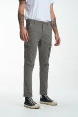 Pantalón cargo gris de gabardina, corte slim, con bolsillos laterales con solapa y bolsillos traseros con ojal y botón. Presenta efecto teñido en la tela.