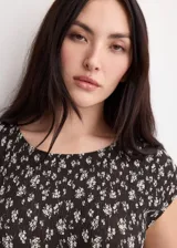 Vestido midi de corte recto con diseño estampado floral en color negro, cuello redondo y manga corta.