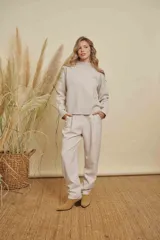Pantalon de vestir color beige, de corte recto y tiro medio. Presenta pinzas frontales, bolsillos laterales y cintura con elástico en la parte posterior.