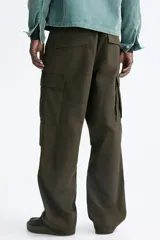 Pantalón cargo de lona de algodón con bolsillos laterales tipo cargo, bolsillos traseros con solapa y pliegues en las rodillas. Presenta cierre con botón y ajuste en la cintura.