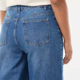 Jean de corte wide leg en color azul, con talle alto y costuras verticales decorativas en el frente. Presenta un diseño de pierna ancha y ruedo recto.