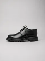 Zapato de cuero negro con cordones y suela chunky de goma con plataforma estriada.