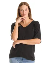 Blusa de silueta fluida con escote en V, manga japonesa corta y costura central vertical en el frente. Confeccionada en tejido de punto con acabado mate, presenta un diseño con largo asimétrico, siendo más larga en la espalda.