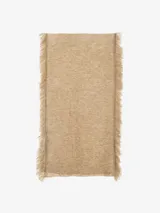 Bufanda tejida de color beige, con textura suave y flecos largos en los bordes. Presenta un tejido envolvente que aporta textura.