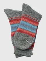 Media de tejido grueso con diseño de rayas horizontales en tonos rojos y azules sobre base gris jaspeada.