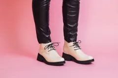 Botinetas de cuero color crema con cordones negros, suela track y plataforma.