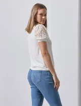 Blusa color blanco de crepe, marca Cable & Gauge. Cuello halter con detalles plisados y mangas cortas de encaje con destellos brillantes.